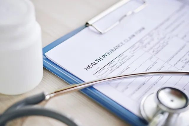 Health insurance claim form and stethoscope on a desk