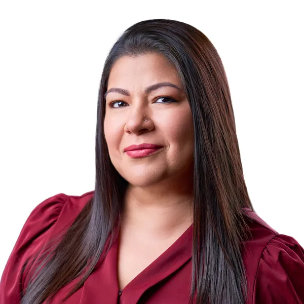 Monica Roman smiling in a burgundy blouse